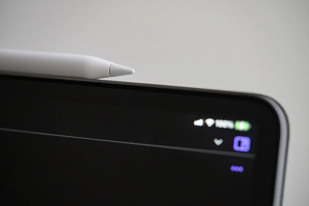 iPad 위에 놓인 Apple Pencil. 앱 화면 비교가 아닌 기기 사진이에요.